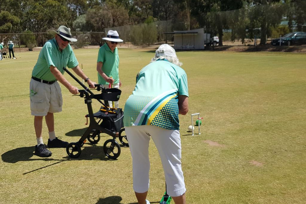 Jean Bourke lining up her shot for the hoop watched closely by Charles Rees & Kneller Lehmann.