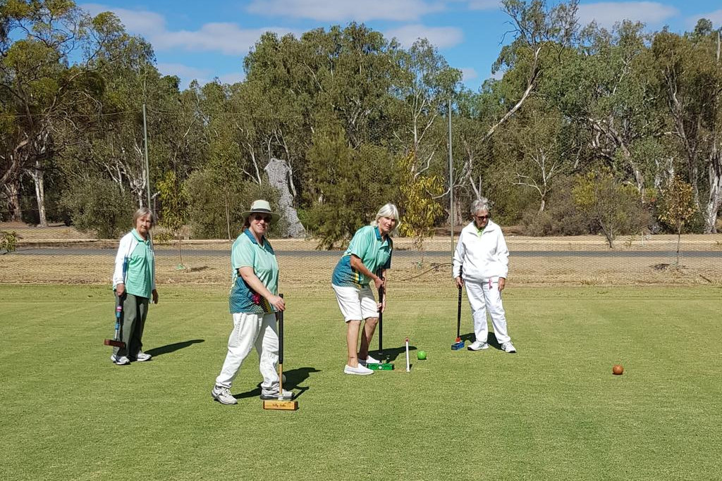 Christine Hiscock hitting the brown ball through the hoop watched by Betty Bartlett, Kelly Walker and Judy Baker.