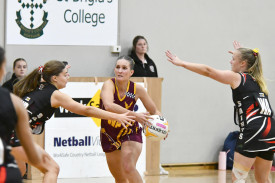 Warrack Eagles’ Nicola Clyne looks down the court while Maddison Bethune and Shannon Cross defend