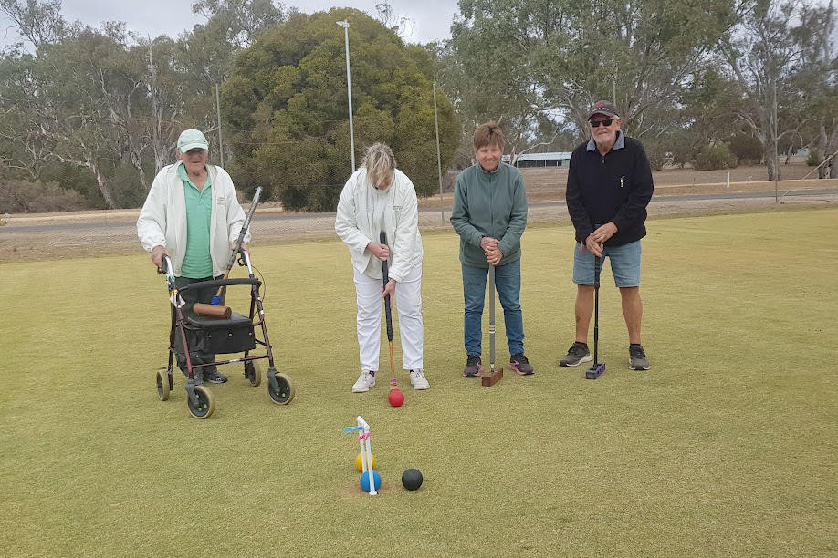 Leanne Combrink lines up the red ball to hit the black out of the way, watched by John Lehmann and two visiting players, Narelle and Terry Wright from Grafton, NSW.