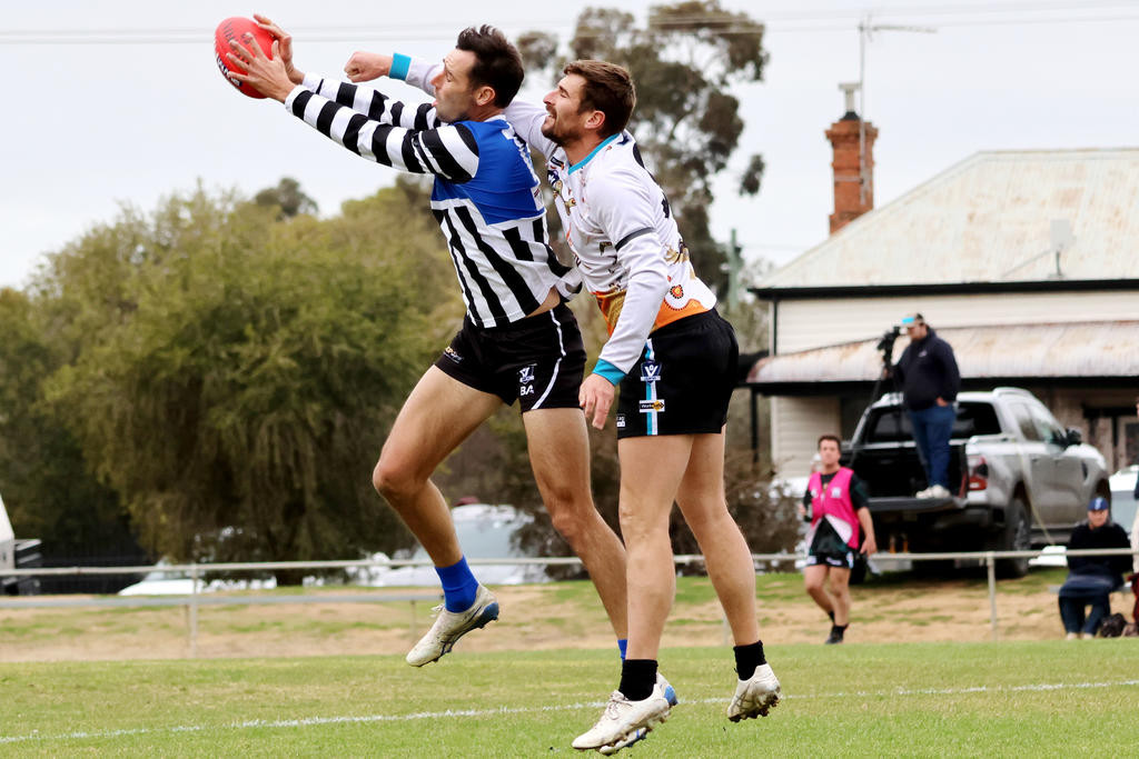 Thunder defender Simon Clugston punches the ball clear of Tanner Smith. Photo: LES GRAETZ