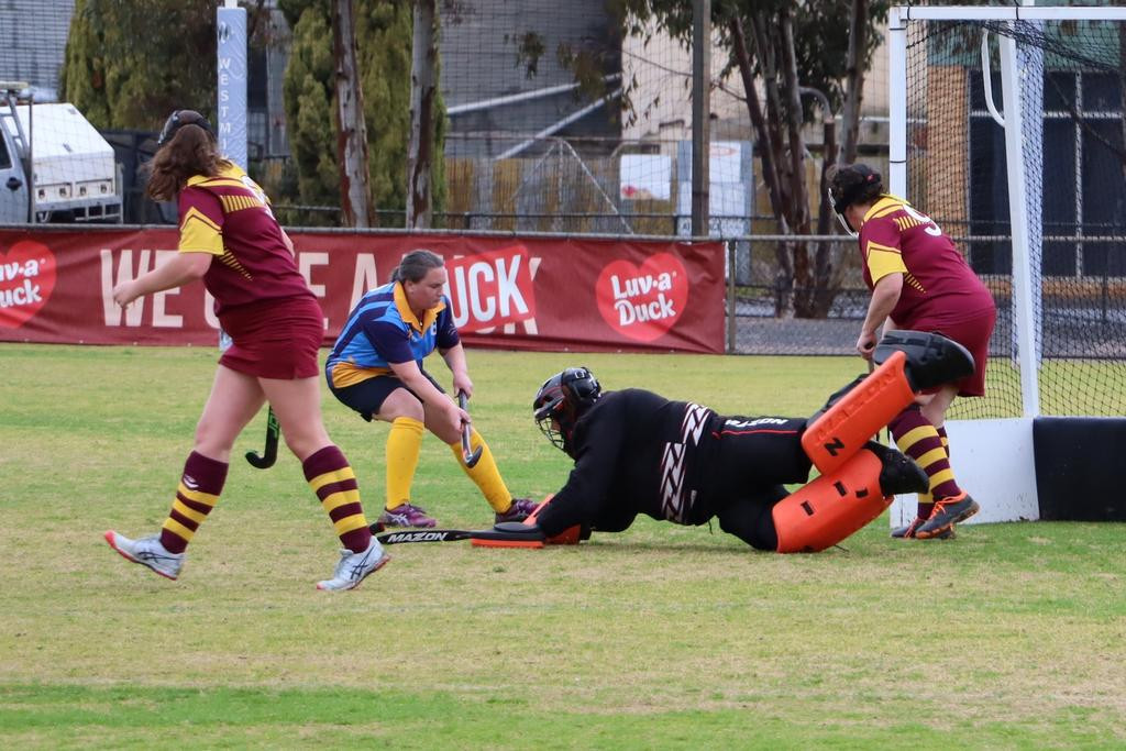 Warrack goalkeeper Mel Bentley dives to stop a shot at goal by Nhill Thunderbirds&rsquo; Rachel Clark.