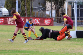 Warrack goalkeeper Mel Bentley dives to stop a shot at goal by Nhill Thunderbirds’ Rachel Clark.