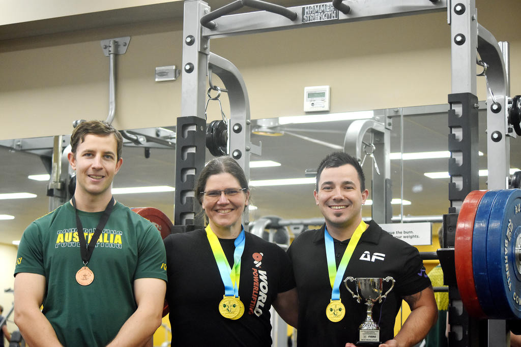Karl Hornsby, Selina Smith and Ben Hogan with their medals and trophies from the Australian Powerlfiting Championships.