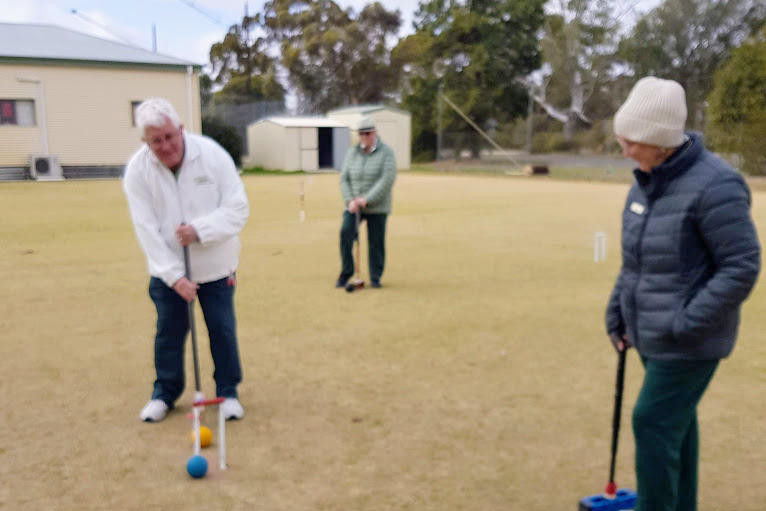John Moar lines up a shot at the hoop, watched closely by Kelly Walker and Judy Baker.