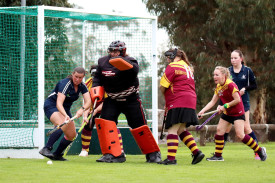 Warrack goalkeeper Mel Bentley leads defenders Cindy Bull, Jess Boyd, and Maryann Paris (obscured) during a penalty corner.