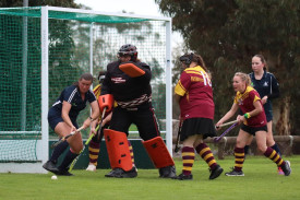 Warrack goalkeeper Mel Bentley leads defenders Cindy Bull, Jess Boyd, and Maryann Paris (obscured) during a penalty corner.