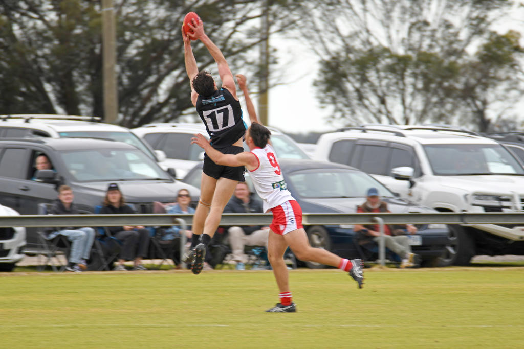 Southern Mallee Thunder's Sam White takes a strong overhead mark, despite pressure from Ararat's James Jennings.