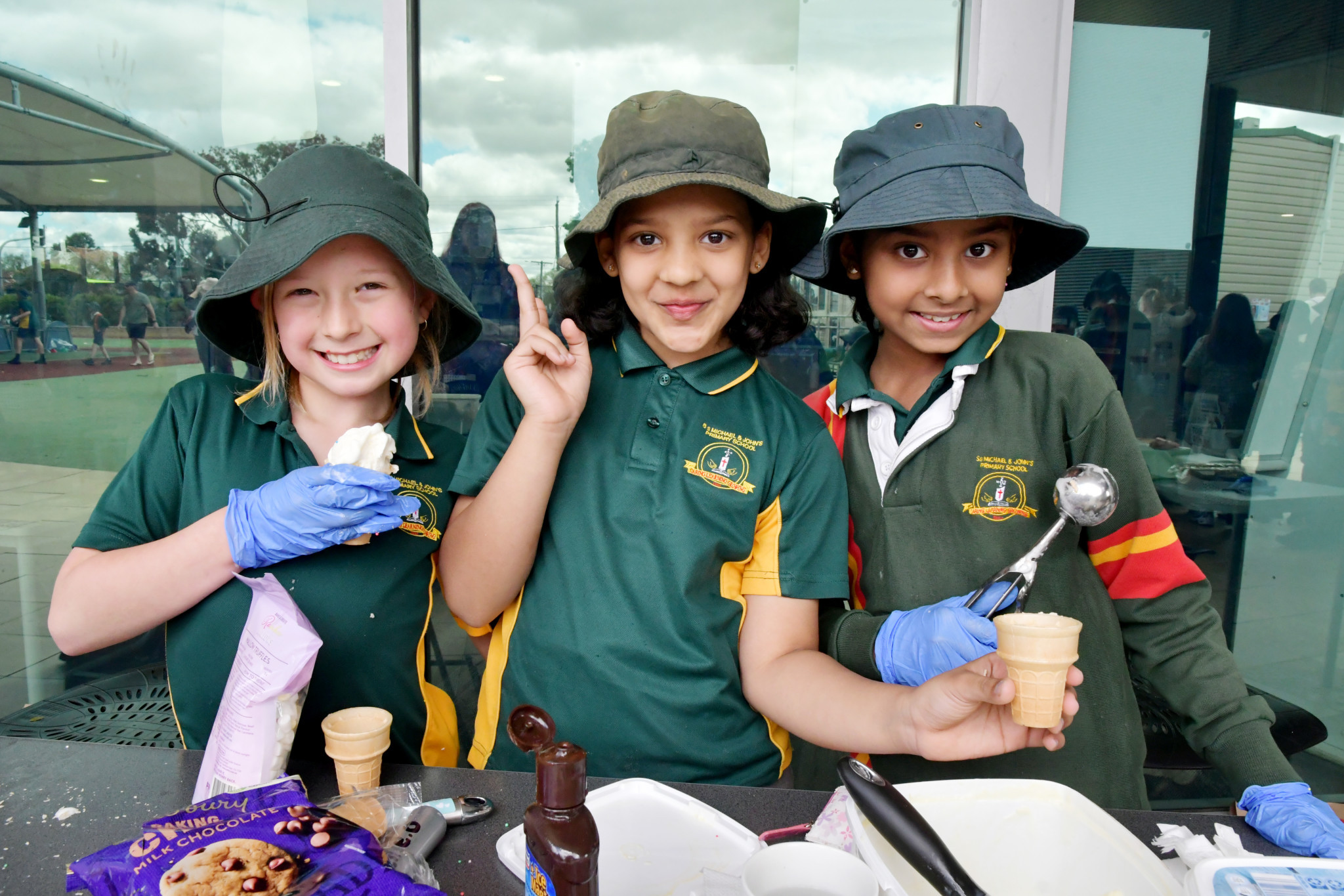 Sienna, Angelin and Thresy serving soft cones on their stall.