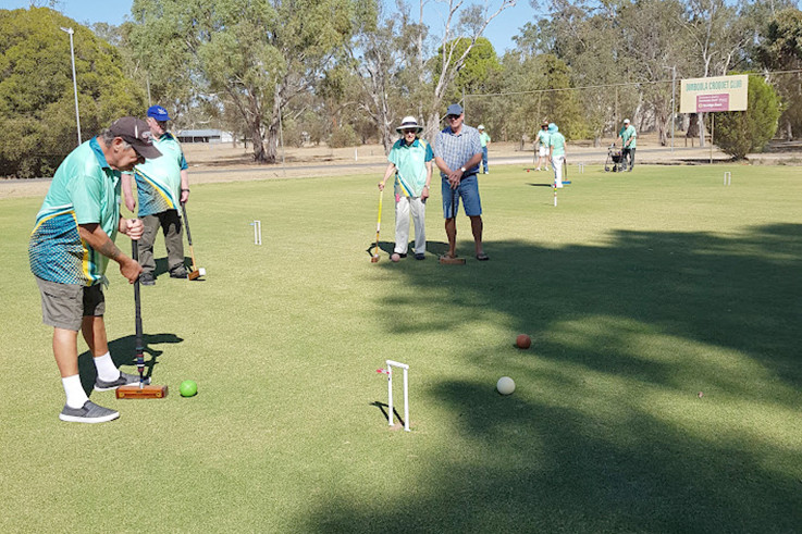 Ray Tritton lines up the green ball for a shot, closely watched by Noel Roberts, Kneller Lehmann and Peter Kilpatrick.