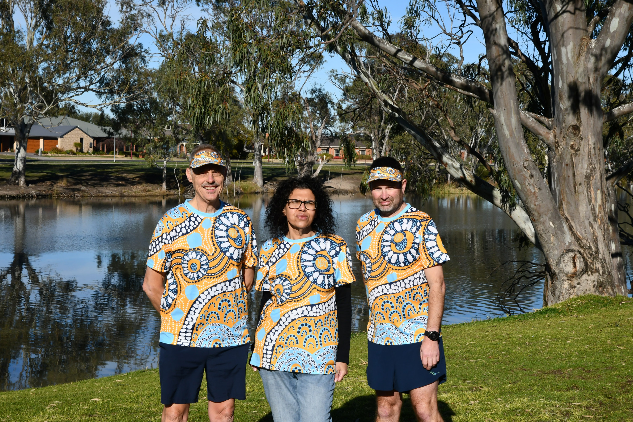 Horsham Running Festival organiser Brian Haddy, artist Michelle Taylor and Wimmera River parkrun director Andrew Sostheim wearing the official shirts and visors, designed by Taylor.