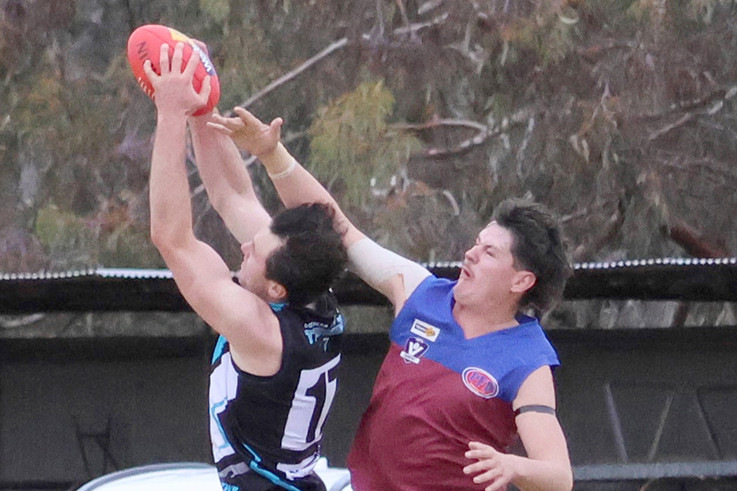 Sam White takes a strong grab in front of his Demons opponent.